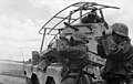 Soldats allemands et voiture blindée en observation. Elle porte une gigantesque antenne-cadre pour les communications radio à longues distances.