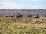 photo of armoured vehicles easy to see on bare hillside