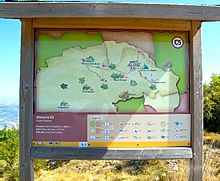 Bacheca di legno con affissa una cartina e la legenda dell'itinerario C5 che porta dall'eremo di san Menna alle vette del monte Pentime