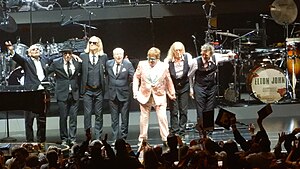 The Elton John Band after performing in November 2018. From left to right: Ray Cooper, Matt Bissonette, Kim Bullard, Nigel Olsson, Elton John, Davey Johnstone, and John Mahon