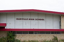 On the side of a gymnasium, the sign reads "Oakville High School".