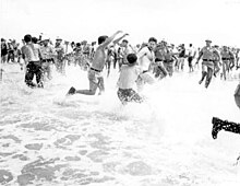 Black and white photograph of segregationists fighting on a beach