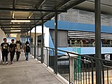 Commuters using the pedestrian link leading to the station.