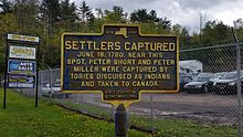 a picture of the marker, with a car dealership behind it