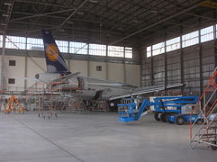 An Airbus A319 undergoing maintenance in a hangar.