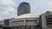 The Red Gate facade Araneta Coliseum in 2018, with the construction of the Gateway Mall 2 in the foreground and the Gateway Mall and Gateway Tower at the background