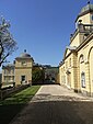 Links: Auffahrt von Castle Hill von unterhalb des Einfahrtsbogens mit Blickrichtung nach Westen zu den schmiedeeisernen Ziertoren zum Innenhof; Flügel für Dienerschaft rechts. Rechts: Nordfassade und Haupthof, gesehen von westlich der Tore des Hofes vor dem Flügel für die Dienerschaft hinter diesem Flügel.