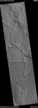 Channel, as seen by HiRISE under HiWish program. Arrow points to a crater that was probably eroded by flowing water.