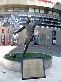A bronze statue outside Estádio da Luz mimics Eusébio before he kicks the ball. In front of it, there is a plaque with information on his football career.