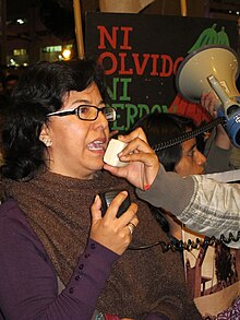 Gisela Ortiz speaks into a megaphone at a protest.