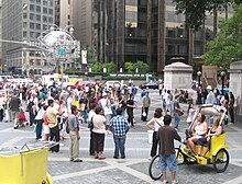 Tourists gather around a busker in Columbus Circle.
