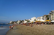 Photograph of a beach lined with visitors