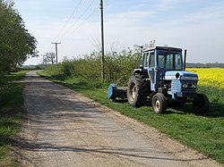 Roadside view near Common Barn, near to Southoe, Cambridgeshire, Great Britain. The tractor is a Leyland Synchro with a flail mower attached.