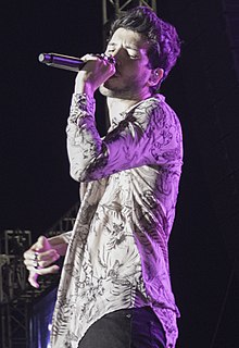 A man holding a microphone on his right hand is singing.
