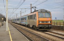 Vue d'une BB 26000 orange en tête d'un train de marchandises