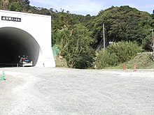 古宮隧道 国道197号の古宮隧道下に佐賀関側の入口跡がある（写真中央）。廃線後しばらくは生活道路の終点ということで放置され草木に覆われていたが、皮肉なことにバイパス道路建設により手前部分の廃線跡が整地されることで容易に近付けるようになった。日鉱古宮駅は国道九四フェリー乗場入口付近にあったが、完全に消滅している。日鉱金山駅は佐賀関病院（製錬所病院→佐賀関町立病院→現在は移転）の前にあったが、これも痕跡を見出すことは難しい。