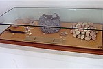 Vitrine du Musée national de Carthage présentant des vestiges du siège avec, entre autres items, boulet, épée, pointes de flèches et balles destinées aux frondes.