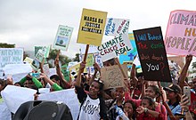 East Timorese youths holding banners about climate change at a protest.