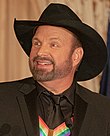 White man looking to the side and wearing black cowboy hat