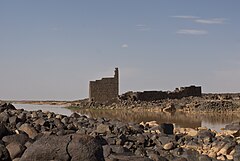 A ruined basalt fortified structure in the desert of modern Jordan