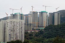 Tower blocks under construction on a forested hill