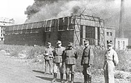 German soldiers in front of a burning Ursus factory