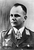 A man wearing a military uniform with an Iron Cross displayed at his neck