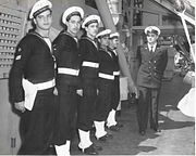 מדי חורף של חוגר חיל הים (בגדי מלחים) עם צוורון מלחים כהה ועם כובע מלחים ייחודי. לצורכי הטקס מתווספים חותלות לבנות (spats) וחגורה לבנה, 1951