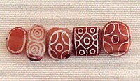 Indus carnelian beads with white design, etched in white with an acid, imported to Susa in 2600–1700 BC. Found in the tell of the Susa acropolis. Louvre Museum, reference Sb 17751.[40][41][42] These beads are identical with beads found in the Indus Civilization site of Dholavira.[43]