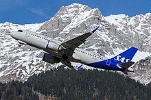 A medium-sized jetliner with a grey body, with "SAS" painted on in a slightly darker shade, two grey engines with blue accents and a blue tail