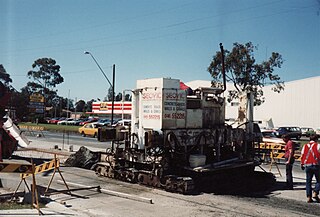 A small concrete road paver called a "slipform paver"