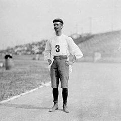 Un homme avec un béret, un pantalon coupé et un maillot avec le numéro 3.