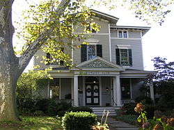 A three-story house with "Woman's Club" written over the door