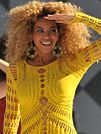 Woman with blonde curly hair wearing a yellow outfit
