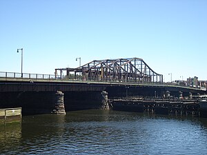 A road bridge with a central truss section over a river