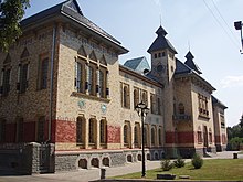 Photograph of a Ukrainian building with ornate tile and brick work on the façade, columned window dressings, and multiple towers