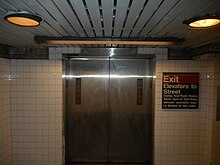One of the elevators leading from the Clark Street Passage to the ground level. There is a sign to the right, indicating that the elevators lead to the station's exit.