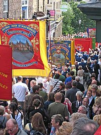 A parade with large traditional trade union banners.