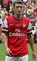 Mesut Özil is classified as having a migrant background because both of his parents were born in Turkey.