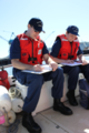 Two Coast Guard auxiliarists review performance qualification workbooks in Portland, Oregon in 2013.