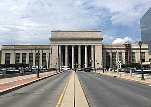 A large Classical Revival train station viewed from the center of a city street