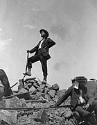 Photographie en noir et blanc d'un homme au sommet d'une montagne.