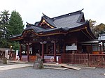 A wooden building with a hip and gable style roof.