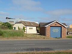 Observatory to rear in elevated position above public toilets and Coastguard building on coast road