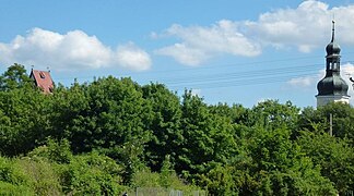 L'église et la tour de la mairie au-dessus des arbres sur la Parthe