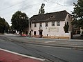 Gasthof "Weißes Roß", 2007. Links im Hintergrund der Haltepunkt. Auf der Straße ist die Überkreuzung von Schmalspurbahn (Lößnitzgrundbahn) und Straßenbahn (ehem. Lößnitzbahn) zu sehen.