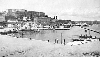 Photographie ancienne : le bassin d'un port surmonté d'une forteresse