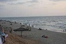 A photo of a sandy beach with relaxing beachgoers