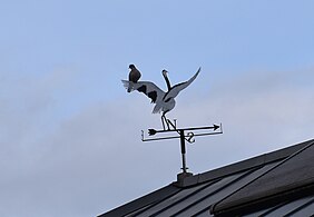 Girouette-cigogne sur laquelle est posée une tourterelle à Mauvezin (Hautes-Pyrénées).