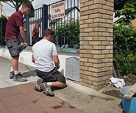 volunteers restoring a commemorative plaque in Finglas, Dublin